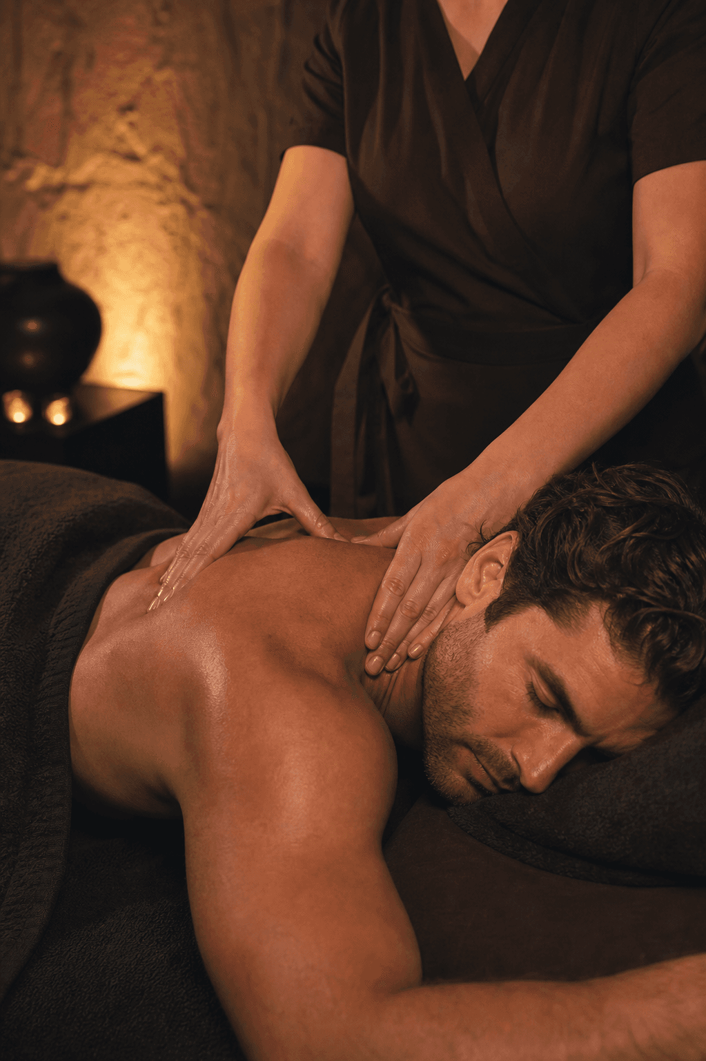 Male guest receiving a restorative shoulder and neck massage from a female therapist
